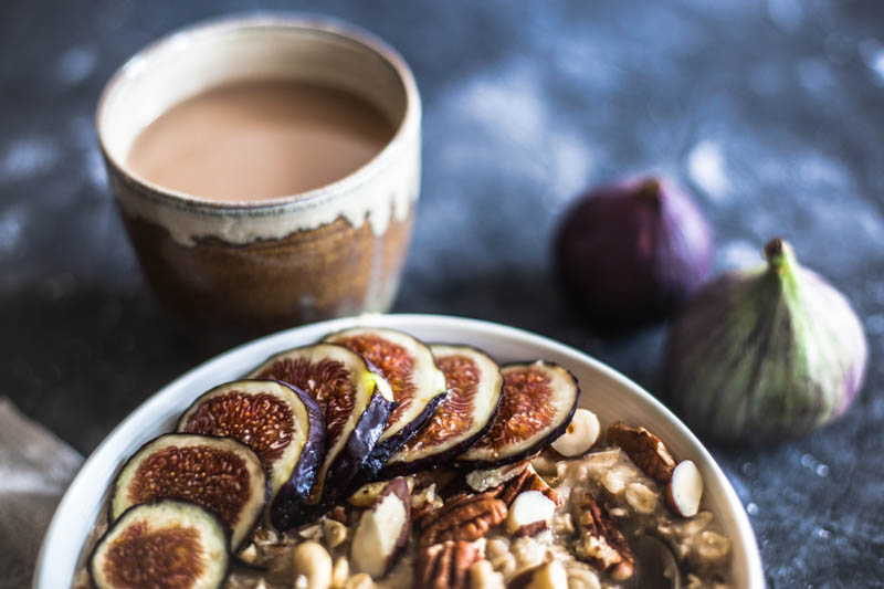 Cooking rolled oats in microwave - a healthy breakfast bowl with chopped nuts and sliced figs