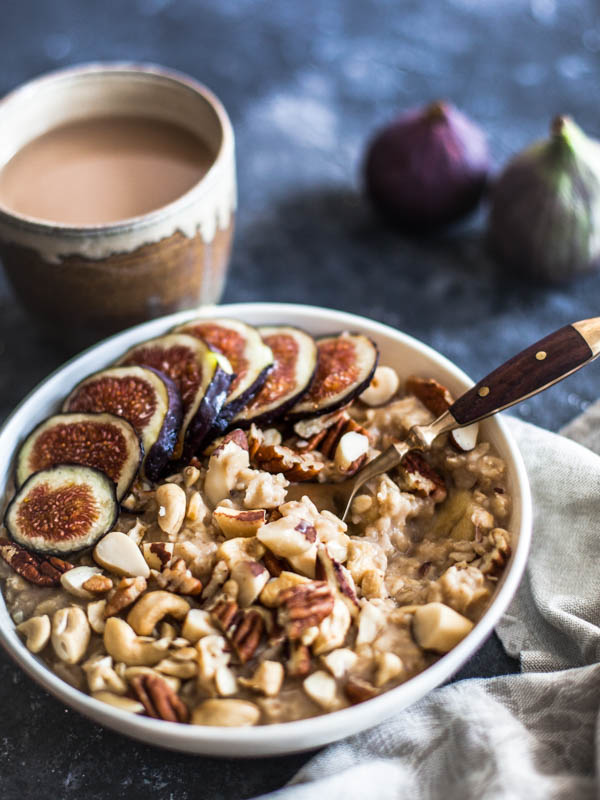 A bowl of microwave oats served with chopped nuts and fresh slices of figs 