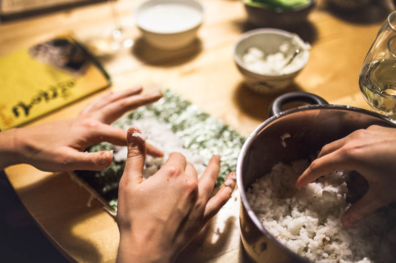 Hands prepping sushi