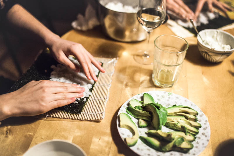 Sushi Reis wird auf einem Nori Blatt verteilt.