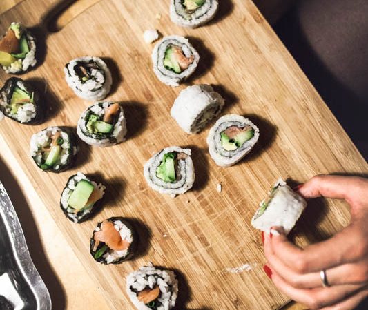 Different pieces of sushi on a wooden cutting board