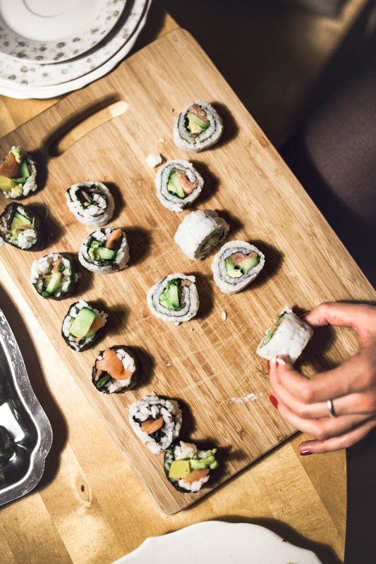 Different pieces of sushi on a wooden cutting board