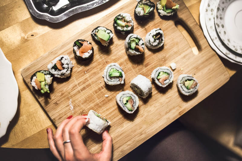 Ein Holzbrett mit unterschiedlichen Sushi Füllung en von oben