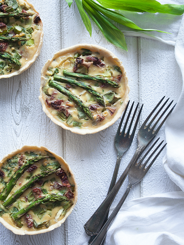 Vegan, gesund und verdammt fotogen, diese Quiche mit grünem Spargel, Bärlauch, Frühlingszwiebeln und getrockneten Tomaten vereint alles. Sie ist einfach und schnell zuzubereiten und beeindruckt auch die kritischsten Gäste!