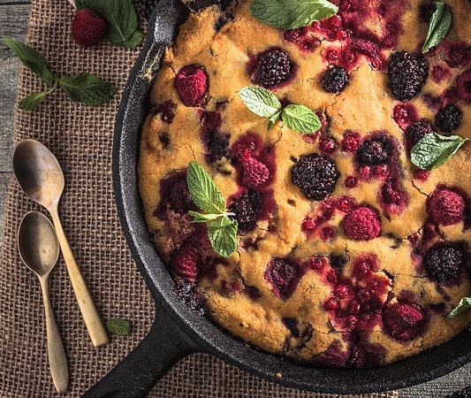 An ethnic recipe for a vegan berry cake freely adapted from a recipe of the Ethno Cookbook by Karolina Przybylska with lots of fresh berrys and maple syrup.