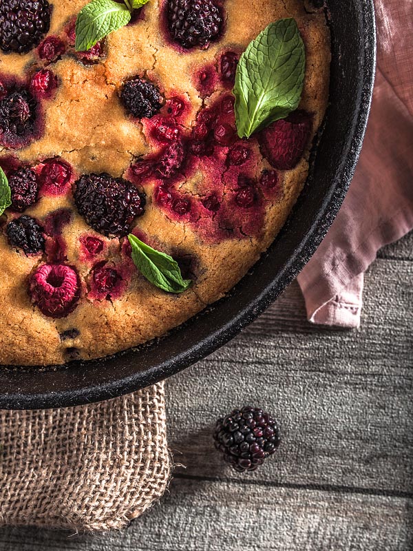 An ethnic recipe for a vegan berry cake freely adapted from a recipe of the Ethno Cookbook by Karolina Przybylska with lots of fresh berrys and maple syrup.