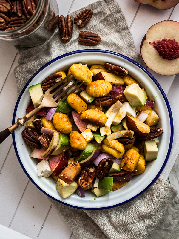 Quick and satisfying Curry Gnocchi Salad with nectarines, feta cheese, roasted pecan nuts and creamy avocado. The perfect summer salad that can be savoured warm and cold and is perfectly suited to be taken out for picnics or barbecue with friends. Recipe and food styling from Purple Avocado / Sabrina Dietz