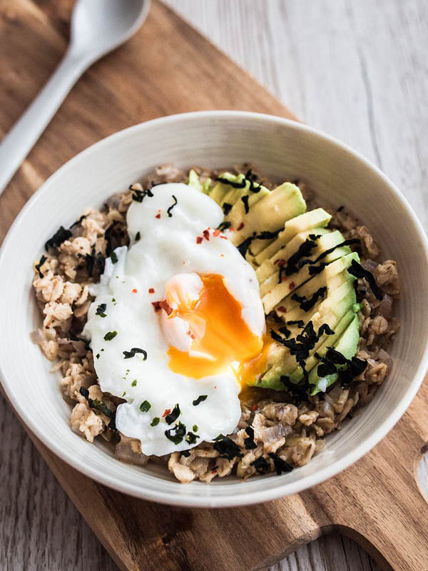 Breakfast becomes dinner with this savoury porridge with avocado, poached egg and roasted sea weed. Recipe and food styling from purple avocado / sabrina dietz.