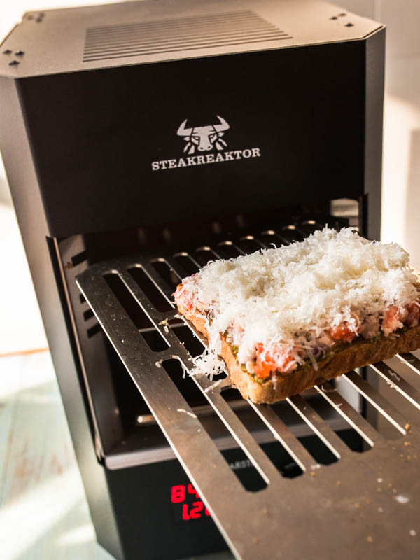 Bruschetta mit Parmesankruste wird in den Steakreaktor geschoben.