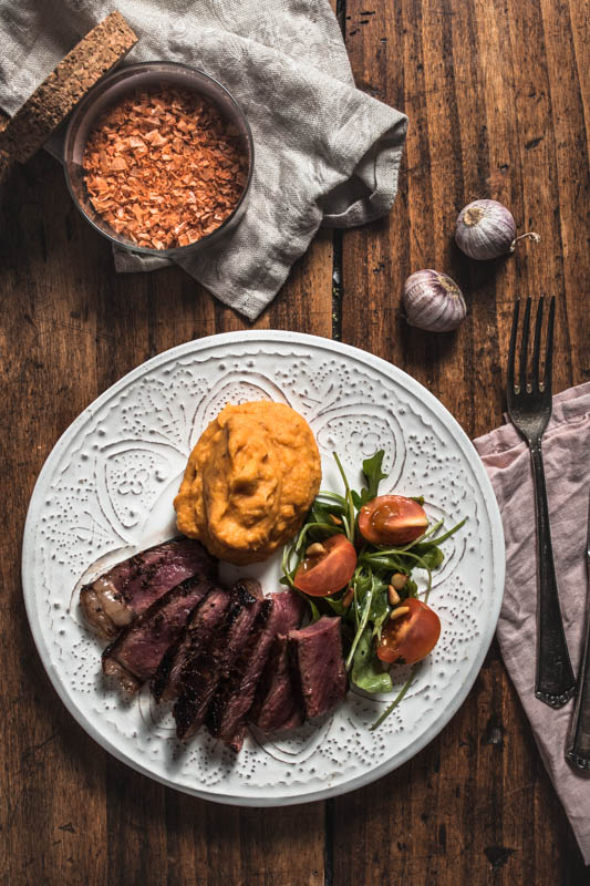 Recipe for garlic maniacs: Creamy garlicky mashed sweet potatoes. The perfect side for any hearty meal. #vegan #sides #potato #recipes #winter #autumn #steak