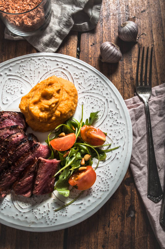 Recipe for garlic maniacs: Creamy garlicky mashed sweet potatoes. The perfect side for any hearty meal. #vegan #sides #potato #recipes #winter #autumn #steak