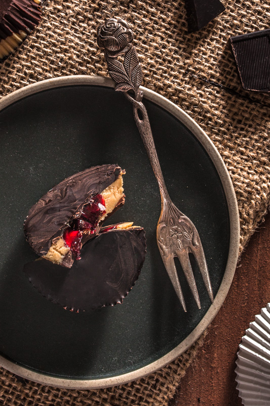Recipe for Reese's inspired peanut butter jelly cups. Peanut butter, jam and dark chocolate in a parliné shape. 5 ingredients only and kind of healthy-ish and vegan. #dessert #sweet #no #valentines #recipe #vegan #healthy