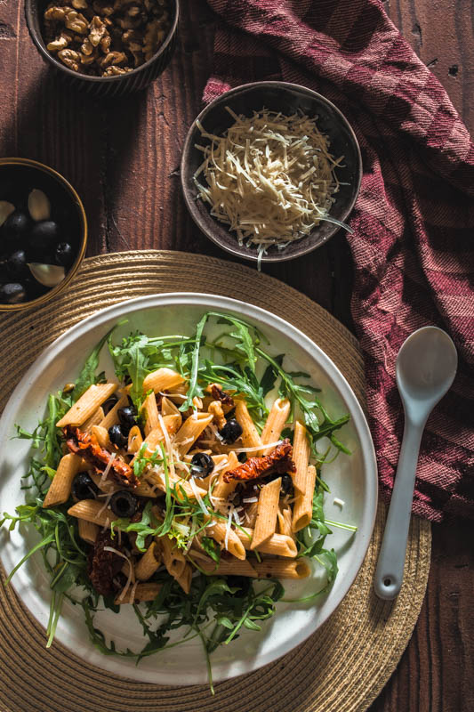 Penne, Oliven, Kapern, getrocknete Tomaten, Walnüsse, frischer Rucola und ganz viel Knoblauch - dieses Pasta-Gericht setzt sich aus ganz einfachen Basics zusammen. Und während wir auf Basic Bitches nicht so abfahren, profitiert unser Rezept definitiv von seiner Schlichtheit. #rezept #nudeln #pasta #italienisch #mediterran #sommer #italien