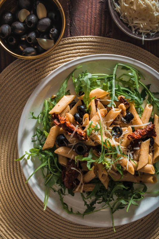 Penne, Oliven, Kapern, getrocknete Tomaten, Walnüsse, frischer Rucola und ganz viel Knoblauch - dieses Pasta-Gericht setzt sich aus ganz einfachen Basics zusammen. Und während wir auf Basic Bitches nicht so abfahren, profitiert unser Rezept definitiv von seiner Schlichtheit. #rezept #nudeln #pasta #italienisch #mediterran #sommer #italien