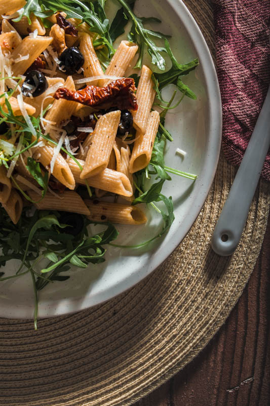 Penne, Oliven, Kapern, getrocknete Tomaten, Walnüsse, frischer Rucola und ganz viel Knoblauch - dieses Pasta-Gericht setzt sich aus ganz einfachen Basics zusammen. Und während wir auf Basic Bitches nicht so abfahren, profitiert unser Rezept definitiv von seiner Schlichtheit. #rezept #nudeln #pasta #italienisch #mediterran #sommer #italien