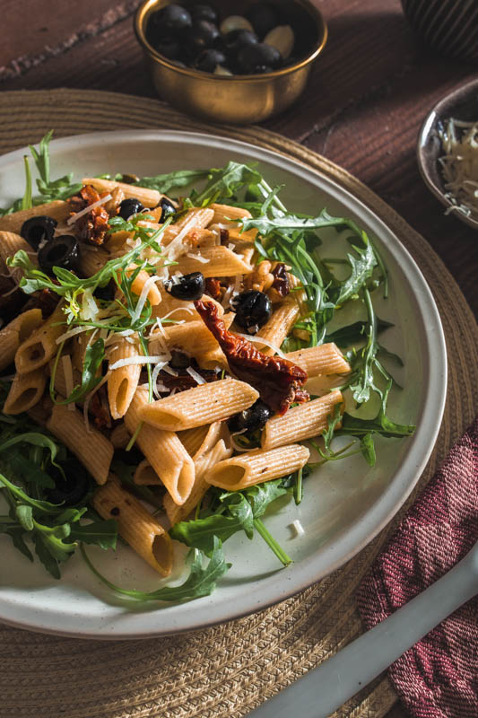 Penne, Oliven, Kapern, getrocknete Tomaten, Walnüsse, frischer Rucola und ganz viel Knoblauch - dieses Pasta-Gericht setzt sich aus ganz einfachen Basics zusammen. Und während wir auf Basic Bitches nicht so abfahren, profitiert unser Rezept definitiv von seiner Schlichtheit. #rezept #nudeln #pasta #italienisch #mediterran #sommer #italien