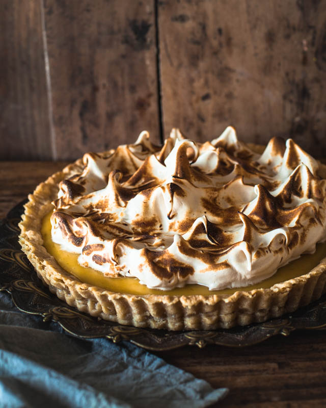 Lemon Meringue Pie on a rustic plate and surface