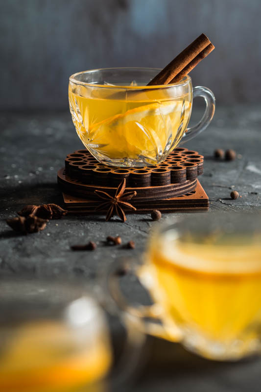 A crystal glass filled with mulled white wine and decorated with a stick of cinnamon