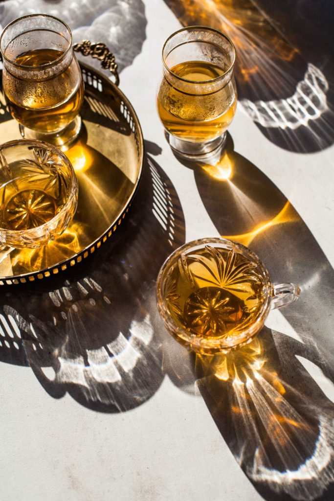 Food Fotografie mit goldenem Tee in Kristallgläsern bei hartem Licht. Fotografiert mit einem Canon 50mm. Die besten Objektive für Food Fotografen
