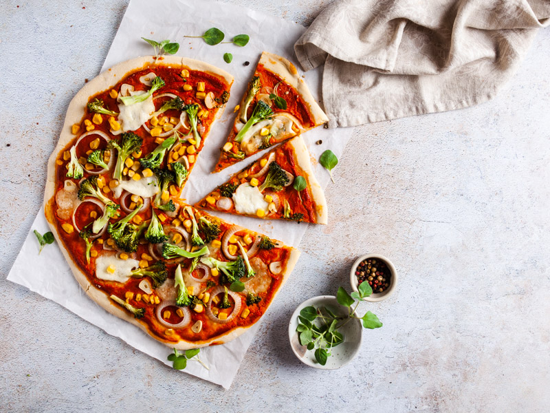 Vegetarische Pizza auf hellem, texsturierten Untergrund. Ein Vinyl Backdrop von PA Backdrops